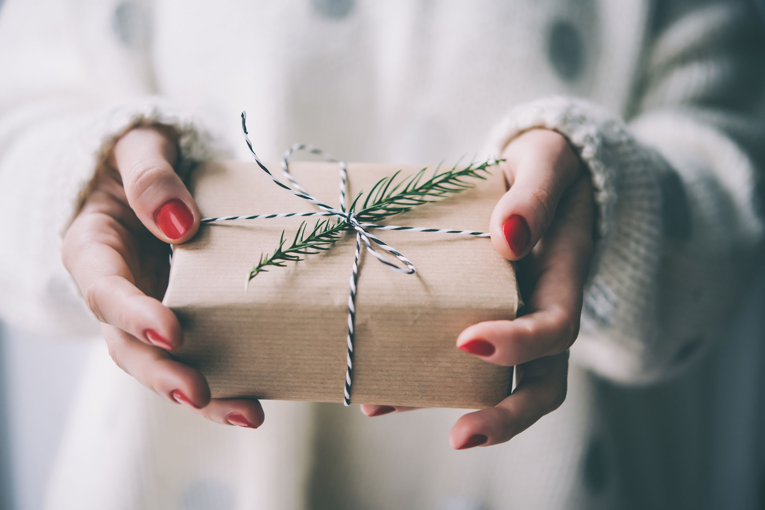 50646106 - woman's hands hold christmas or new year decorated gift box. toned picture